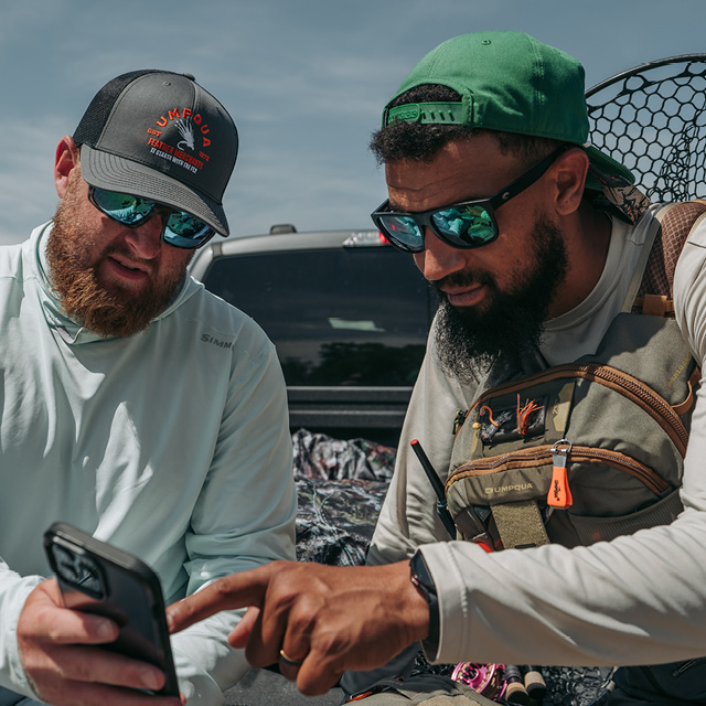 2 men planning fishing in the back of a truck